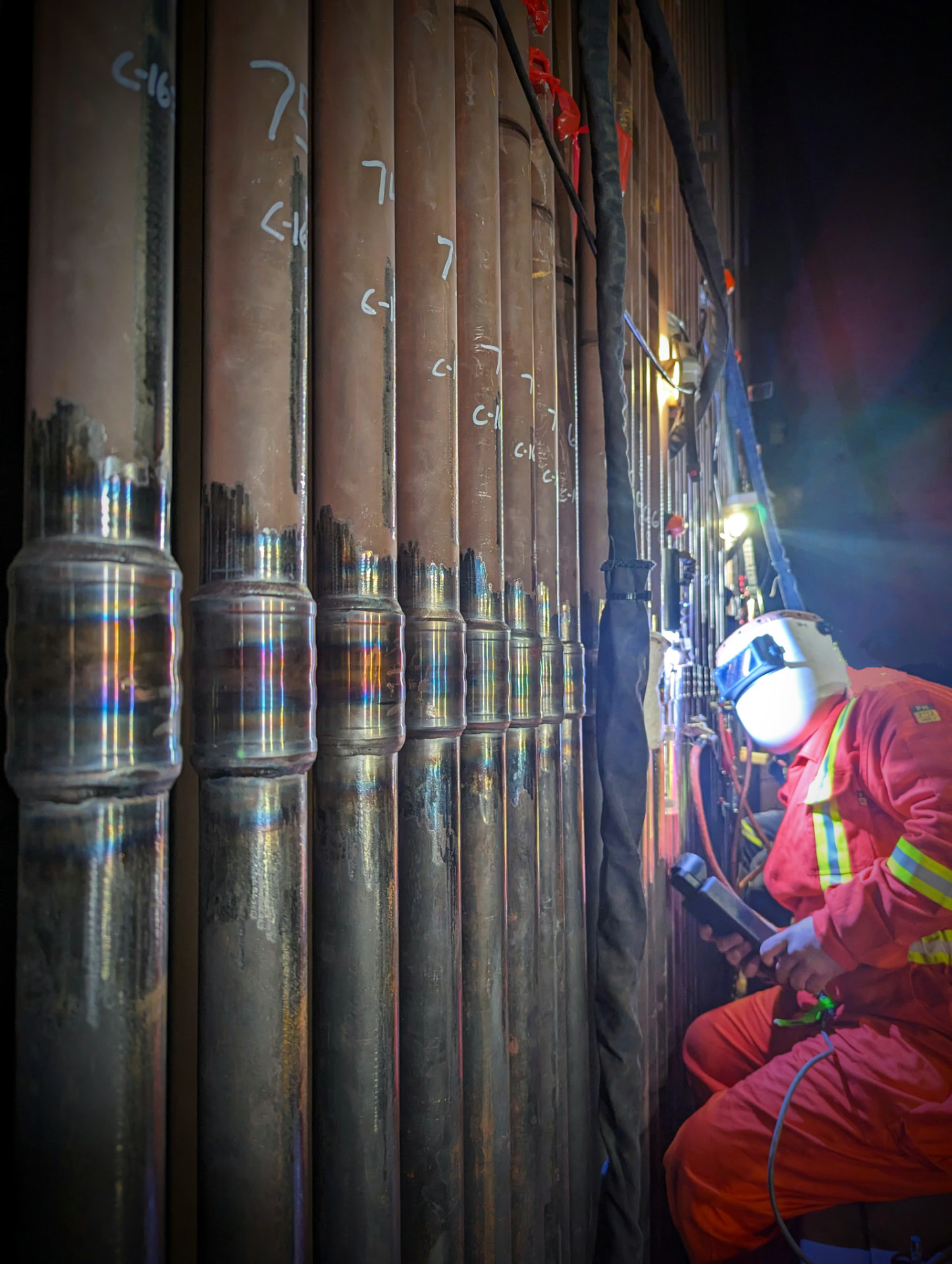 Operator using mechanized orbital welding equipment on a row of TTT connections